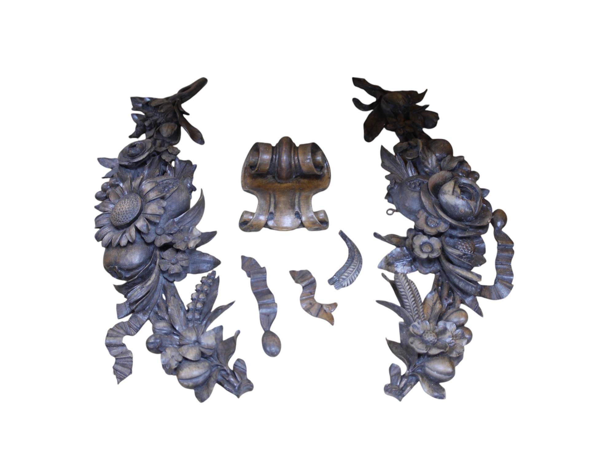 A pair of late 19th/early 20th century carved beech ‘fruit and flower’ wall appliqués and a similar corbel, 70cm long. Condition - fair